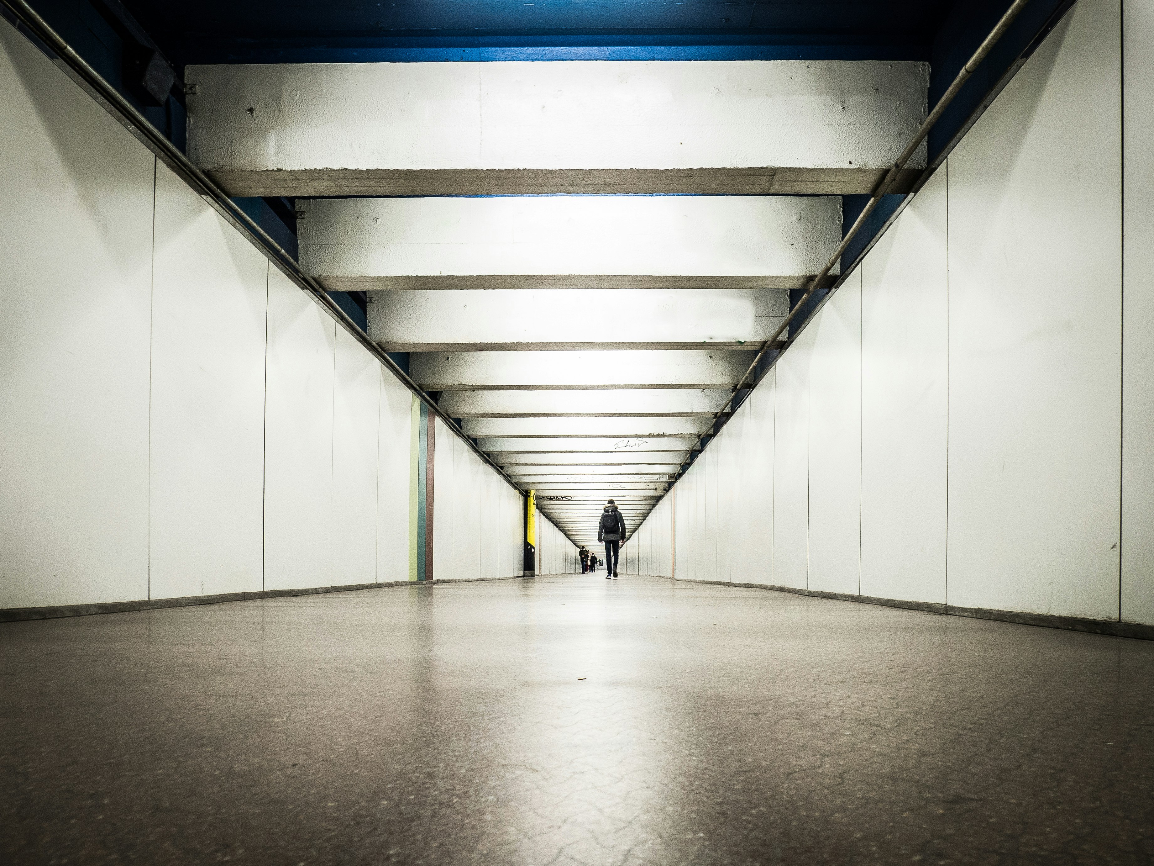 person in black jacket walking on hallway